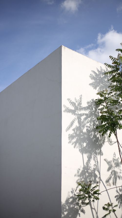 Free A minimalist white building with tree shadow casting under a blue sky in Izmir. Stock Photo