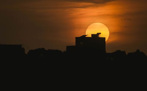 Free Silhouettes of modern buildings and trees during amazing breathtaking bright sunset over city Stock Photo