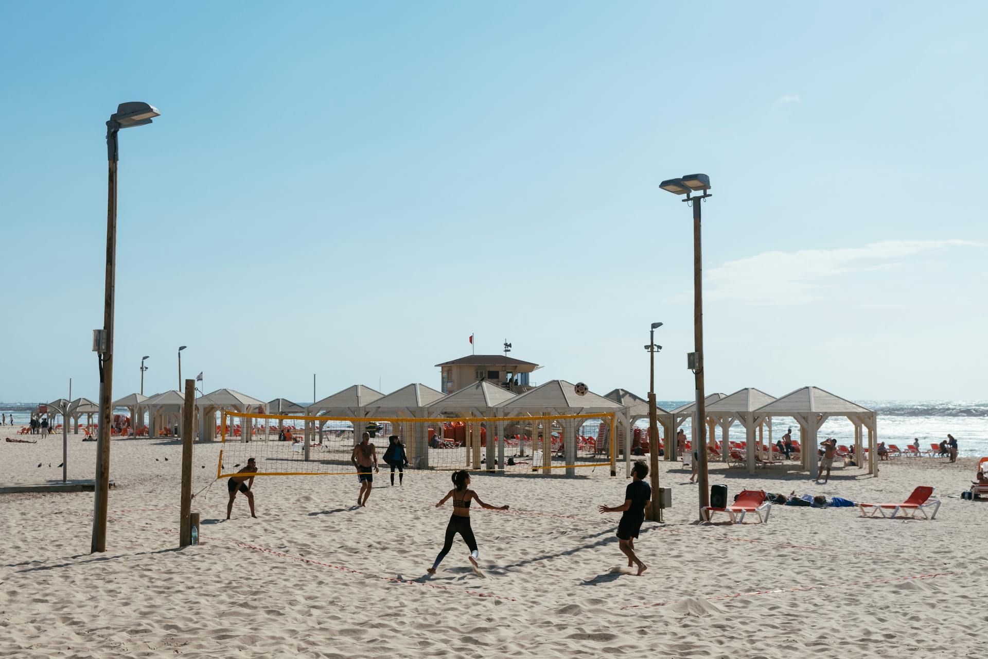 People enjoying beach volleyball on a sunny day at Tel Aviv beach, Israel.