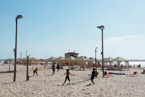 Free People enjoying beach volleyball on a sunny day at Tel Aviv beach, Israel. Stock Photo