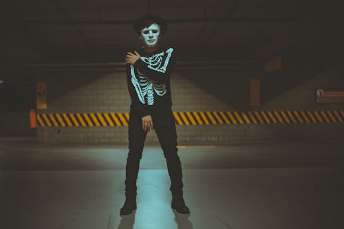 Homme Debout Portant Un Costume De Squelette Sur Une Zone éclairée Tamisée