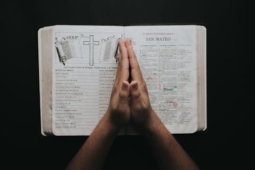 Person Placing Hands On Bible