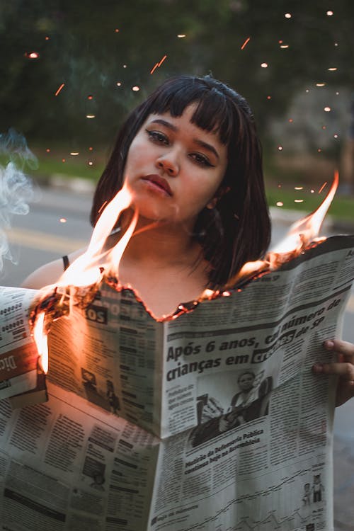 Free Woman Holding Burning Newspaper  Stock Photo