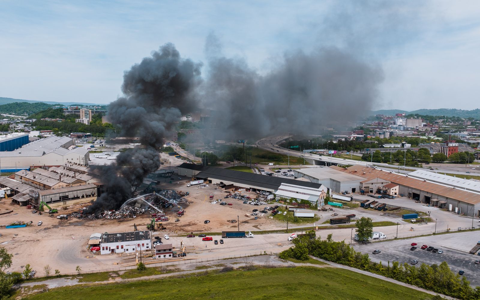 Aerial view of black smoke rising from a fire in an industrial area
