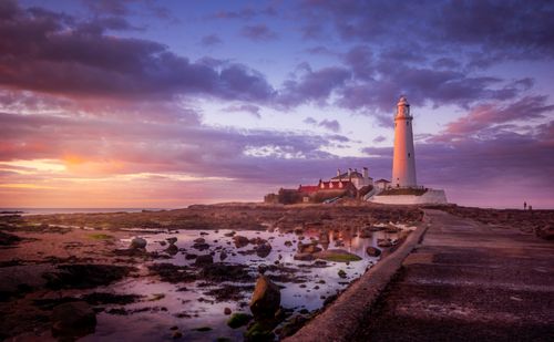 Free Scenic sunrise over Saint Mary's Lighthouse with vibrant sky and reflections. Stock Photo