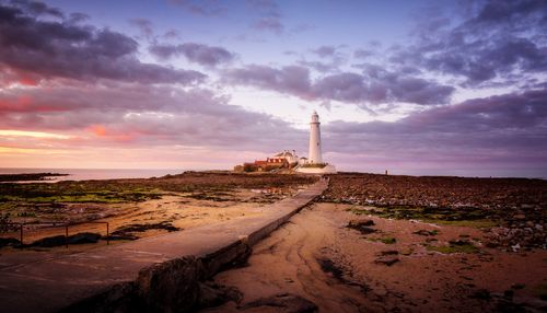 Free Capture the serene beauty of St Mary's Lighthouse against a vibrant sunset sky. Stock Photo