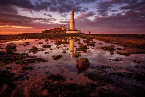Free Beautiful sunset view of St Mary's Lighthouse reflected in the North Sea at low tide. Stock Photo