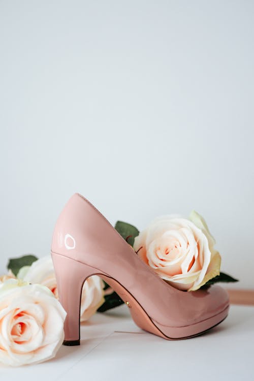 A pair of pink shoes with roses on them