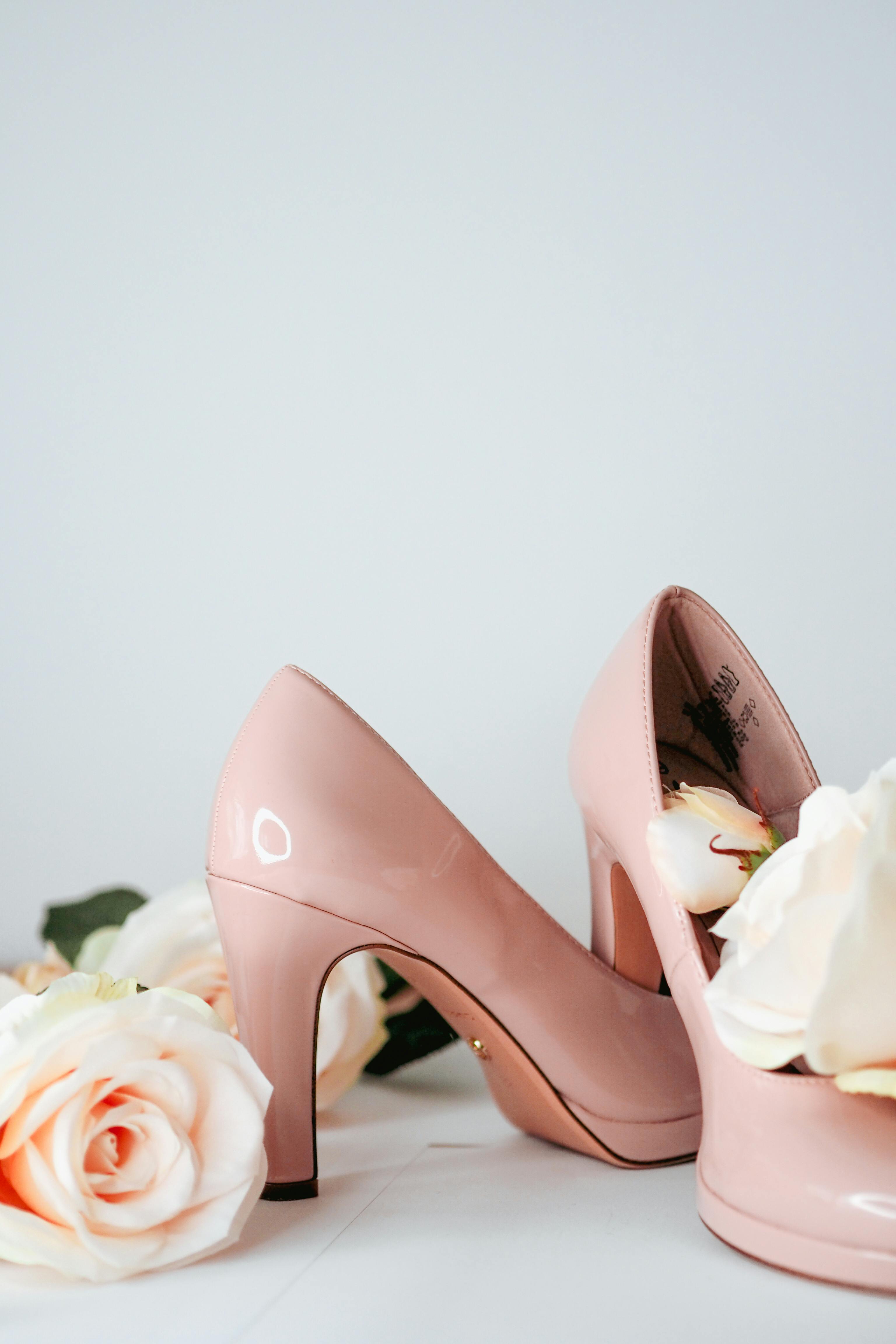 Soft pink high heels paired with roses, perfect for bridal fashion or decor inspiration.