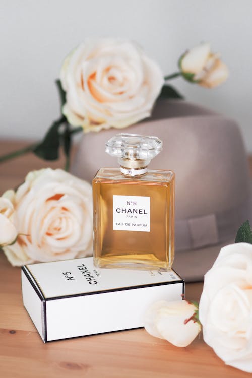 Chanel perfume with roses and a hat on top
