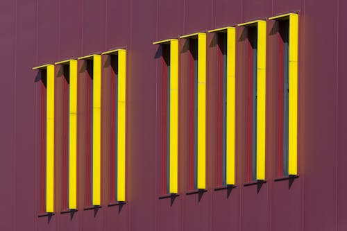 A row of yellow and red poles on a building