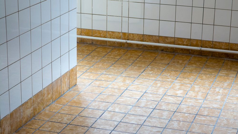 A clean, empty interior space with tiled flooring and walls, showcasing minimalist design.