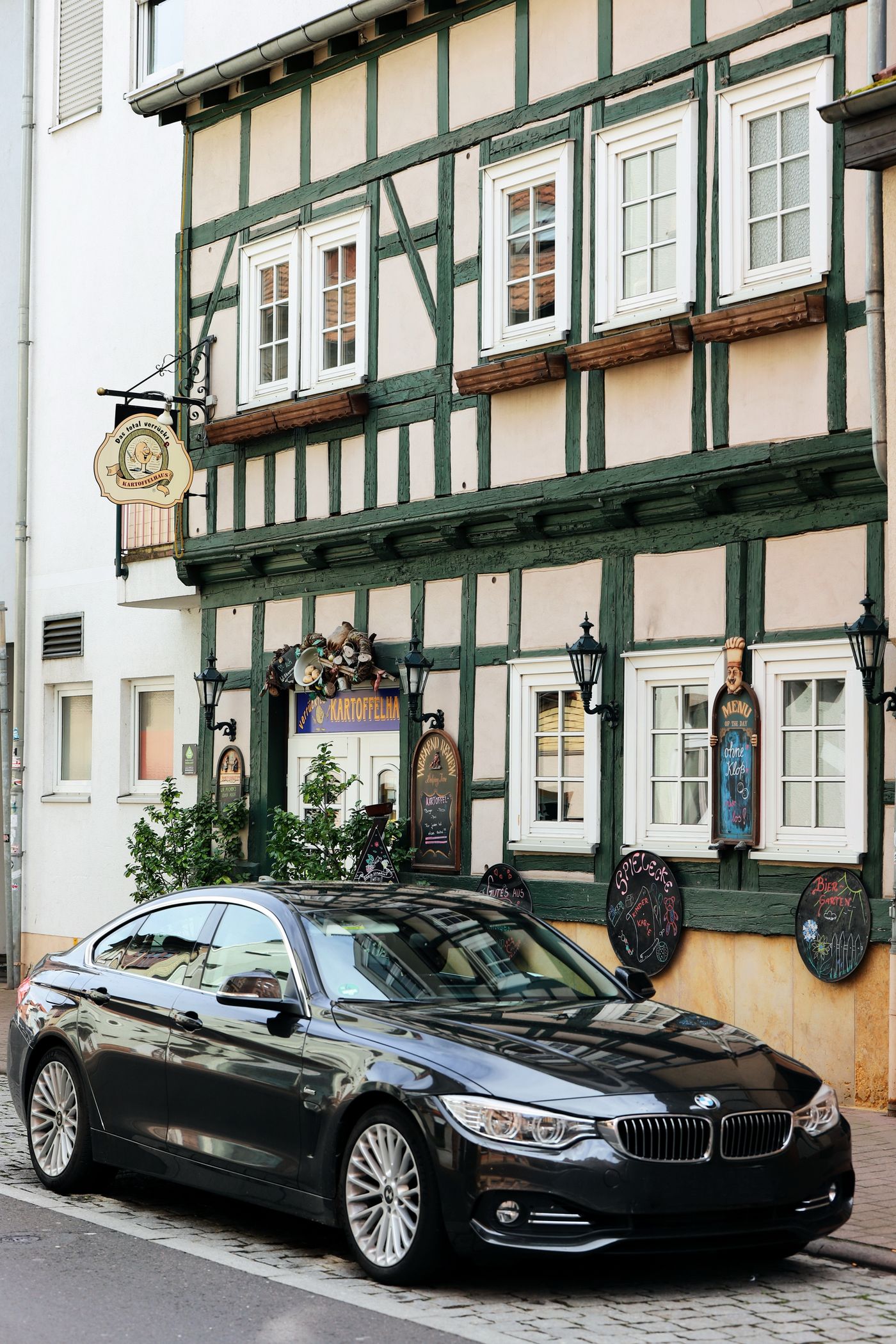 Black automobile parked beside a timber-framed building
