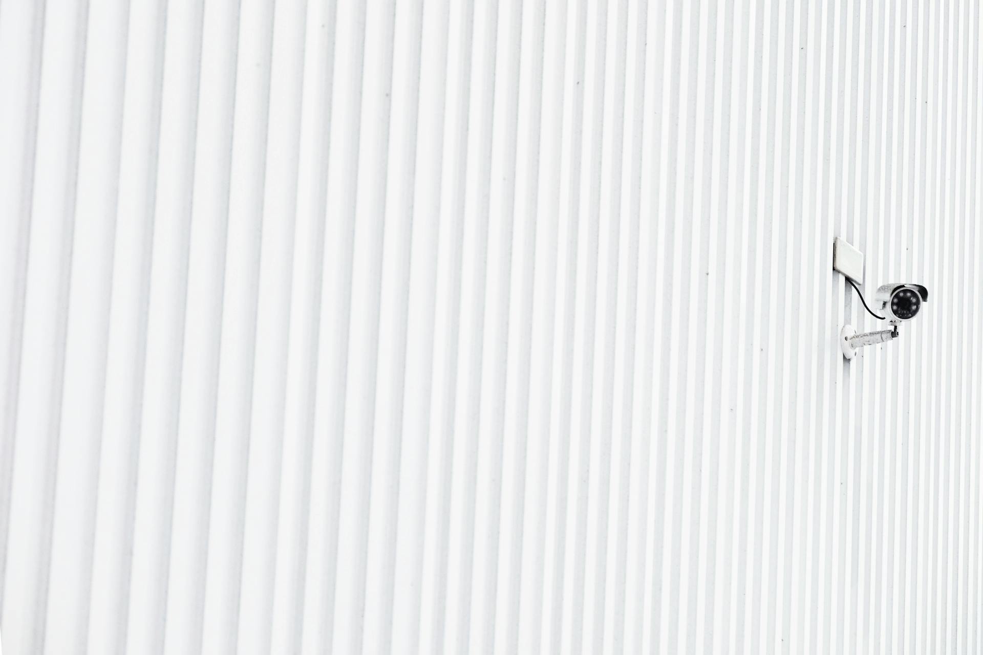 A minimalist photo of a security camera mounted on a corrugated wall, emphasizing privacy.