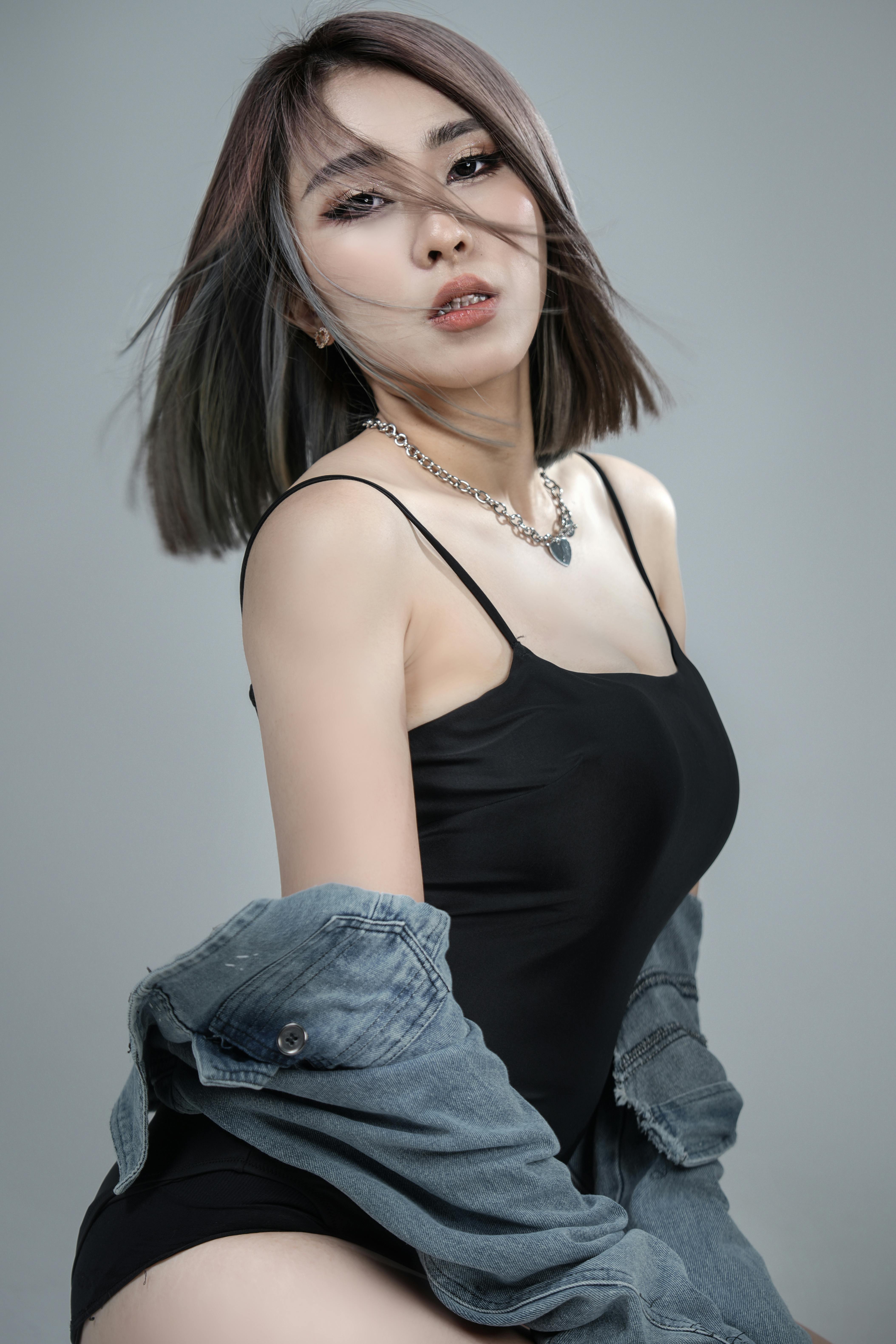 Elegant young woman in black bodysuit posing confidently in a studio shoot.