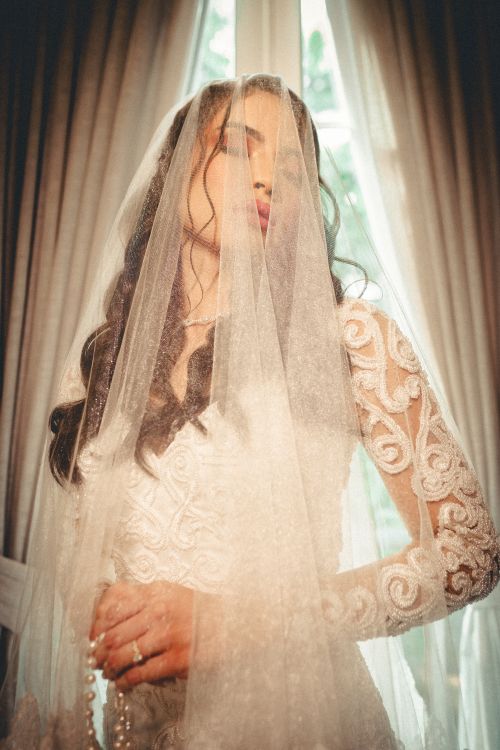 Free Bride standing in a lace dress with a veil, elegant wedding shot. Stock Photo