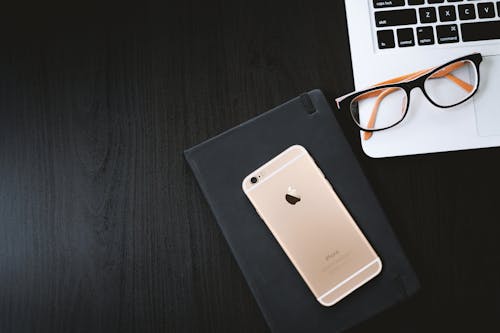 Iphone 6 Dourado Na Capa Preta Além Dos óculos No Macbook Prateado