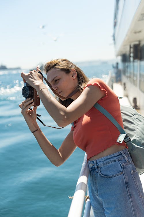 A woman taking a picture of the ocean from a boat
