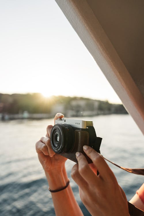 A person taking a photo with a camera on a boat