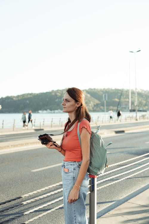 Woman standing on the side of the road with her phone