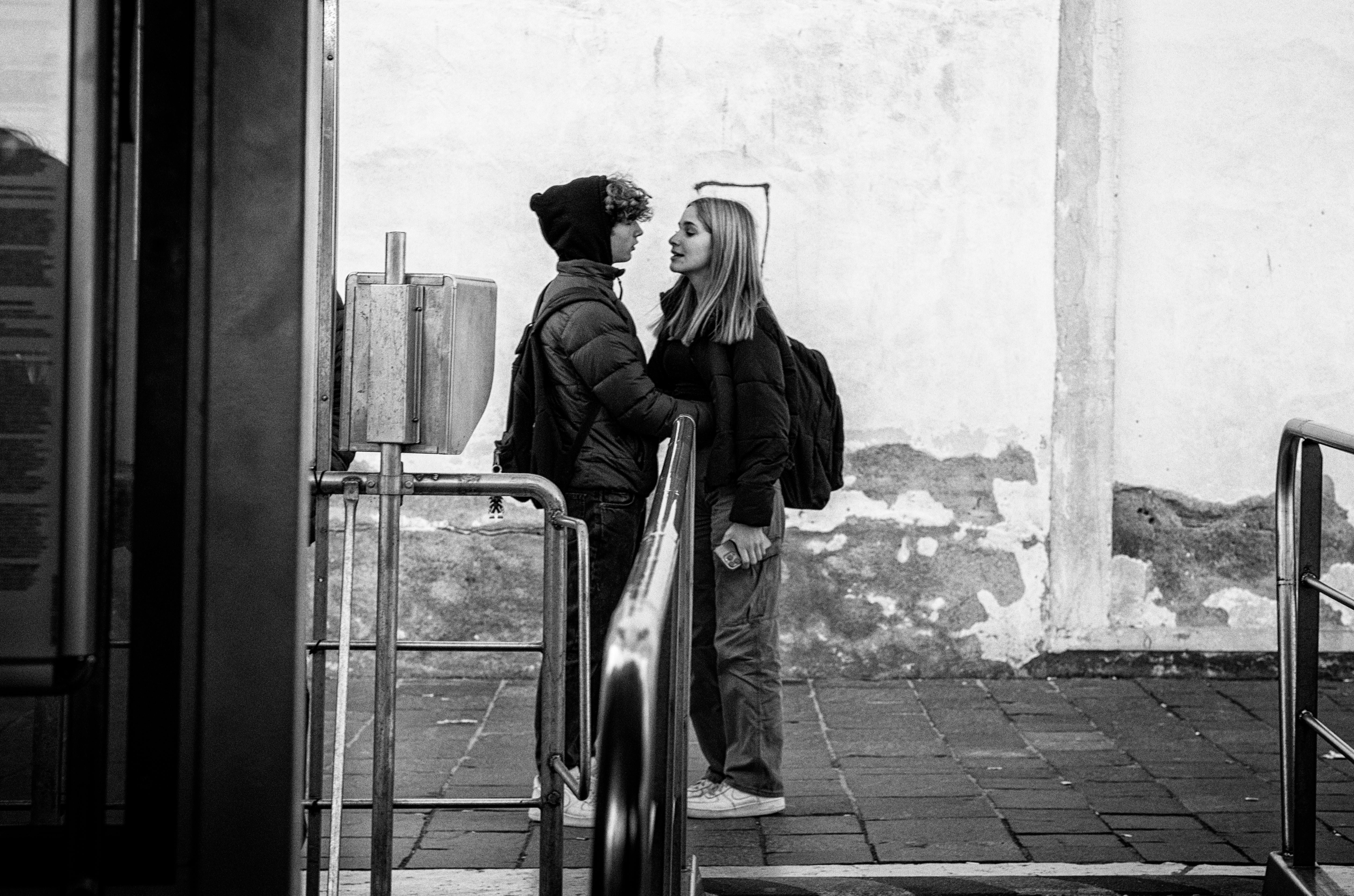 A young couple shares a moment in an urban environment, conveying connection and emotion.