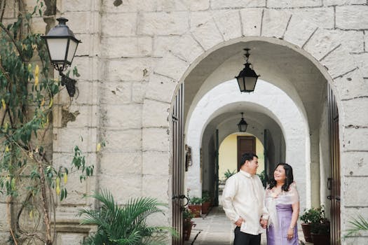 Smiling Asian couple enjoys a moment together at Casa Manila's archway in the Philippines.