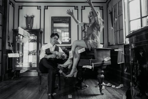 Cuplu glam aruncând bani într-un cadru vintage