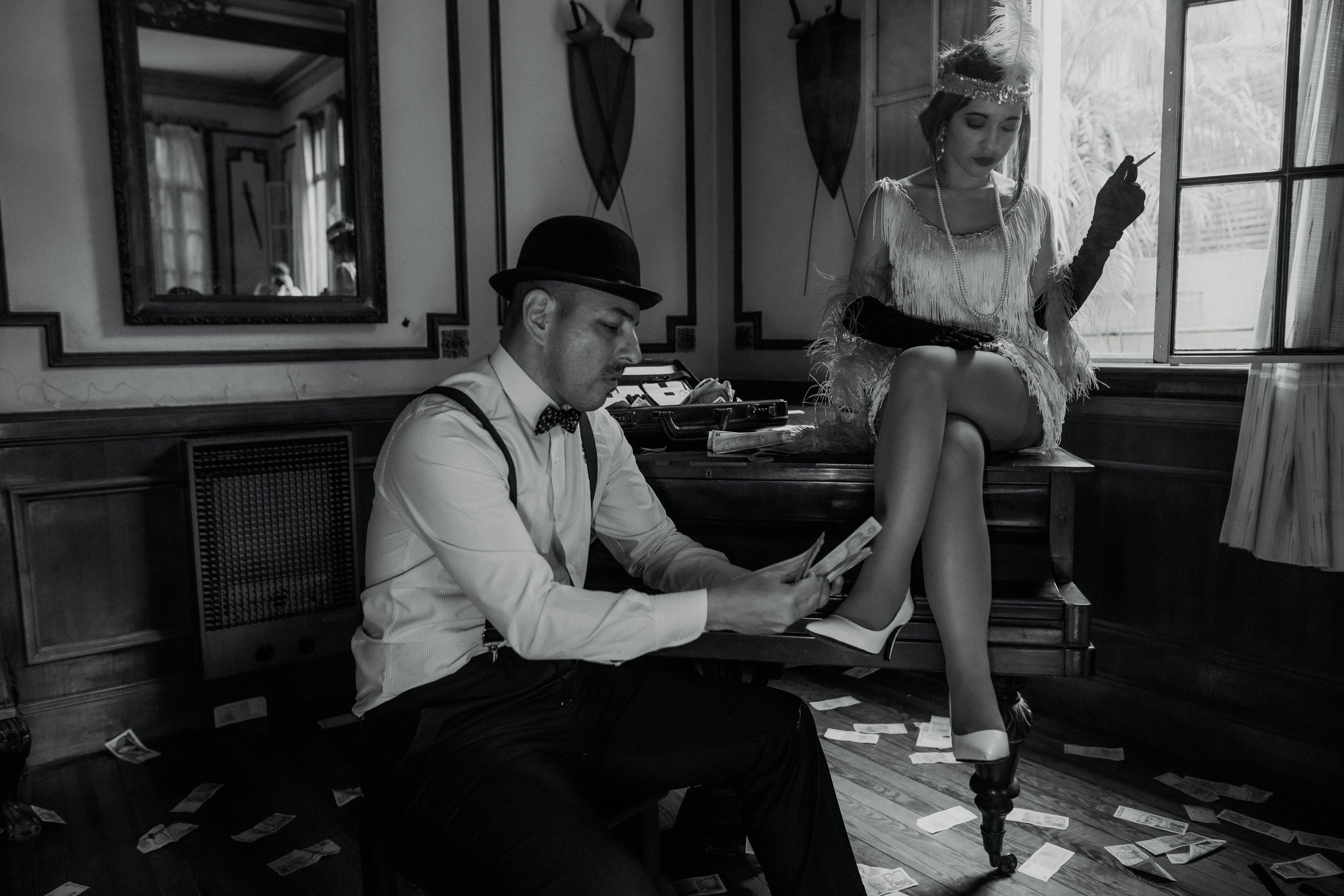 Man Counting Banknotes and a Woman Sitting on a Piano and Smoking a ...