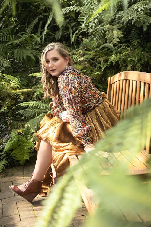 A woman in a floral dress sitting on a bench