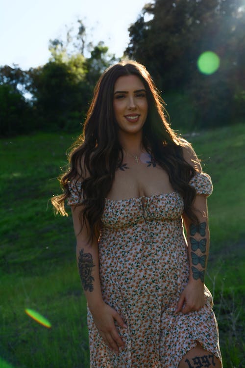 A woman with tattoos standing in the grass