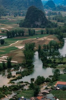 Breathtaking bird's-eye view of Cao Bằng's lush green countryside with rice fields and karst hills.