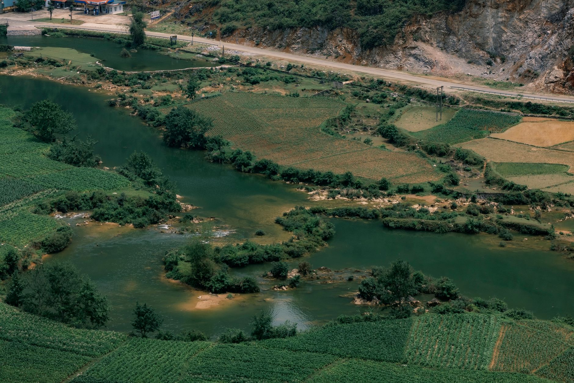 Explore the lush fields and winding river captured in an aerial view of Cao Bằng, Vietnam.