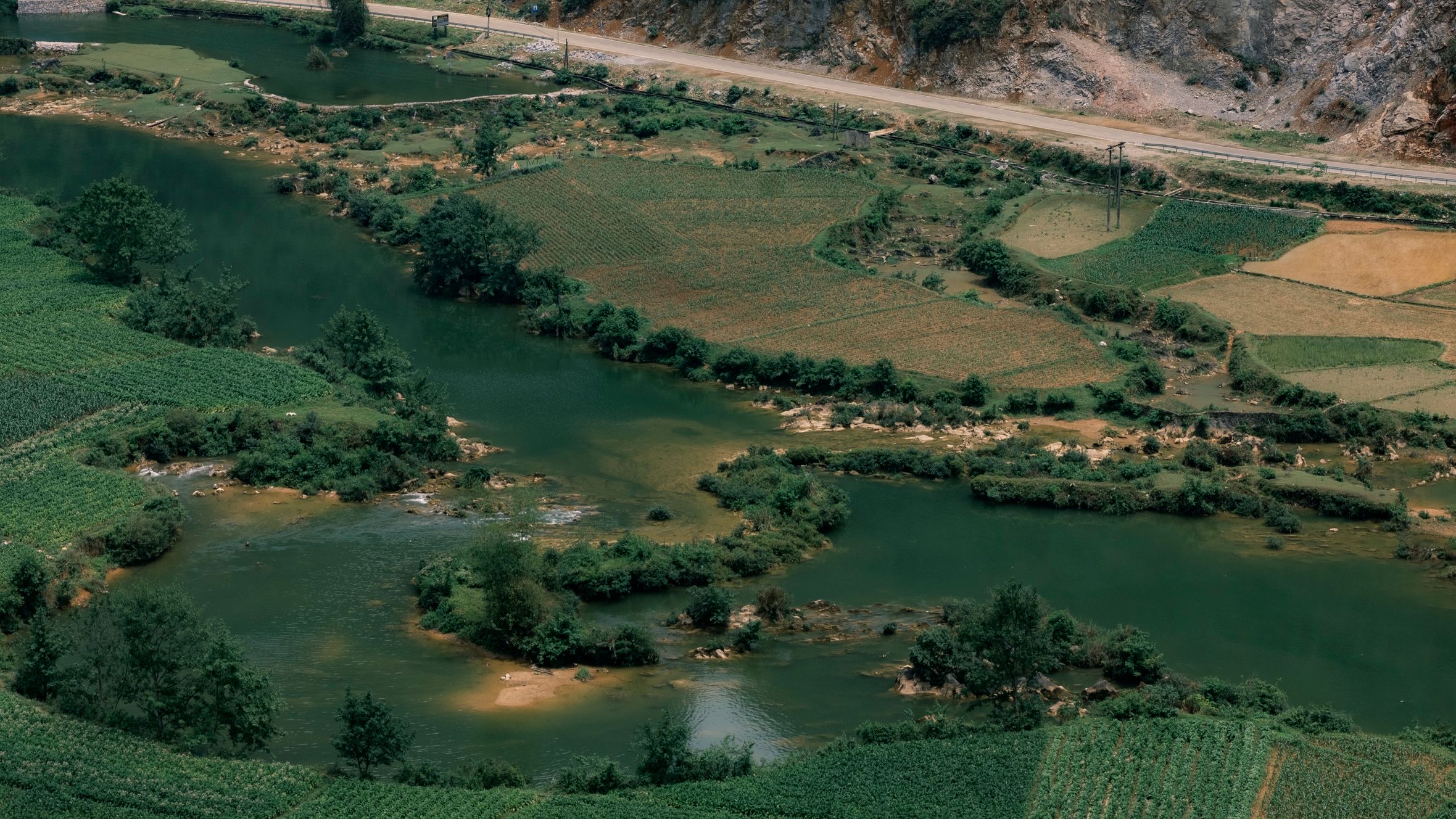 Explore the lush fields and winding river captured in an aerial view of Cao Bằng, Vietnam.