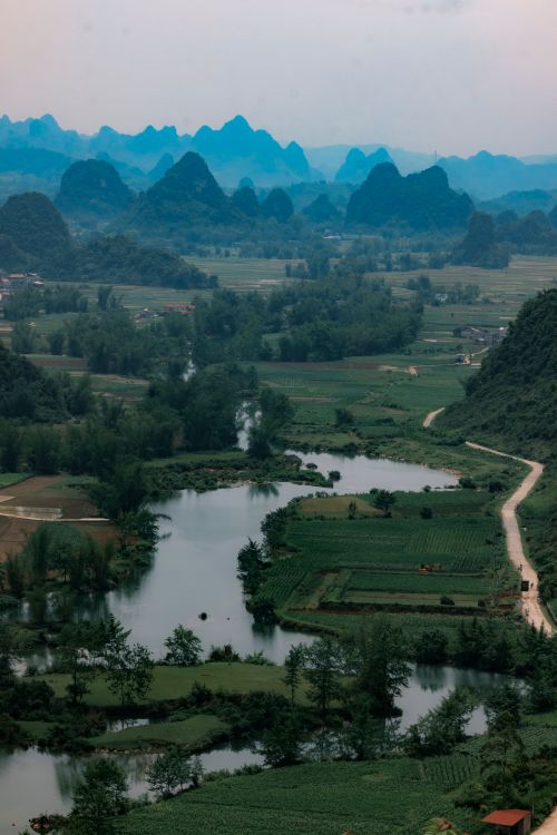 Free Stunning aerial shot of Cao Bằng, Vietnam capturing verdant hills, winding roads, and serene lakes. Stock Photo