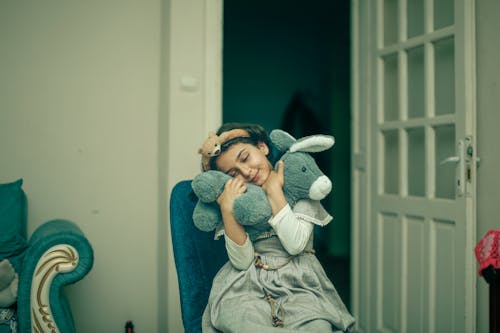 A young girl is hugging a stuffed animal