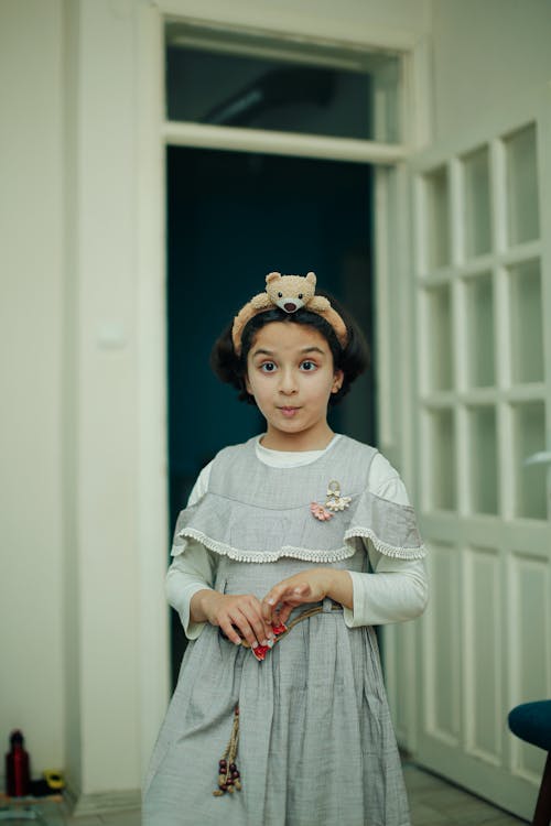 A young girl in a dress and headband