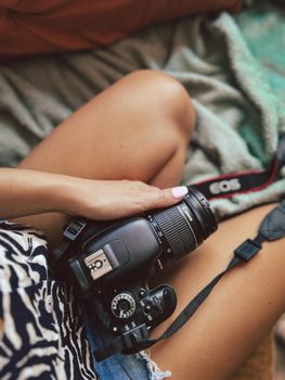 Close-up of a woman holding a camera, showcasing casual photography in a relaxed indoor setting.