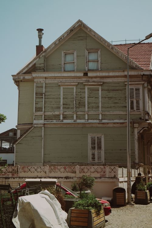 Free Charming vintage wooden house on a sunny urban street, showcasing classic architecture. Stock Photo