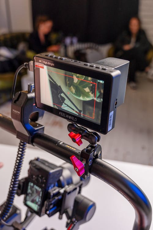 A camera mounted on a tripod with a monitor