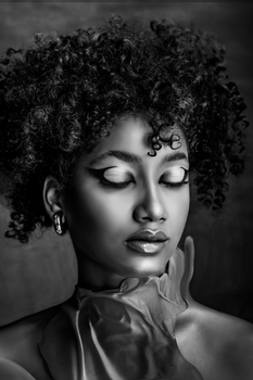 Striking black and white portrait highlighting the beauty of a woman with curly hair and eyes closed.