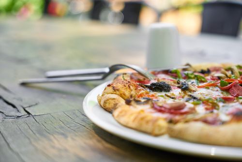 Free A mouth-watering vegetable pizza with crust, peppers, and olives on a rustic outdoor table. Stock Photo