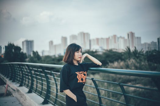 在城市天际线背景的桥上摆姿势的女人