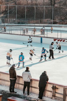 A lively youth ice hockey match at an outdoor rink in Central Park, New York City.