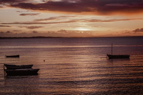 Free Tranquil scene of boats floating on the sea during a vivid sunset, highlighting the beauty of nature. Stock Photo