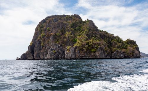 Free Explore a stunning rocky island with lush vegetation surrounded by the ocean's vibrant blue waters. Stock Photo