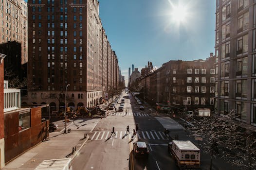 纽约市白天街景繁忙，摩天大楼林立，交通和行人川流不息
