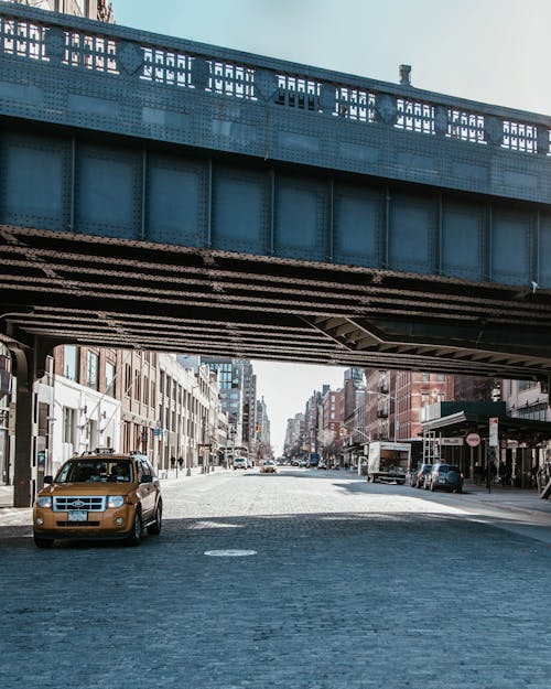 Taxi Passing Under Bridge