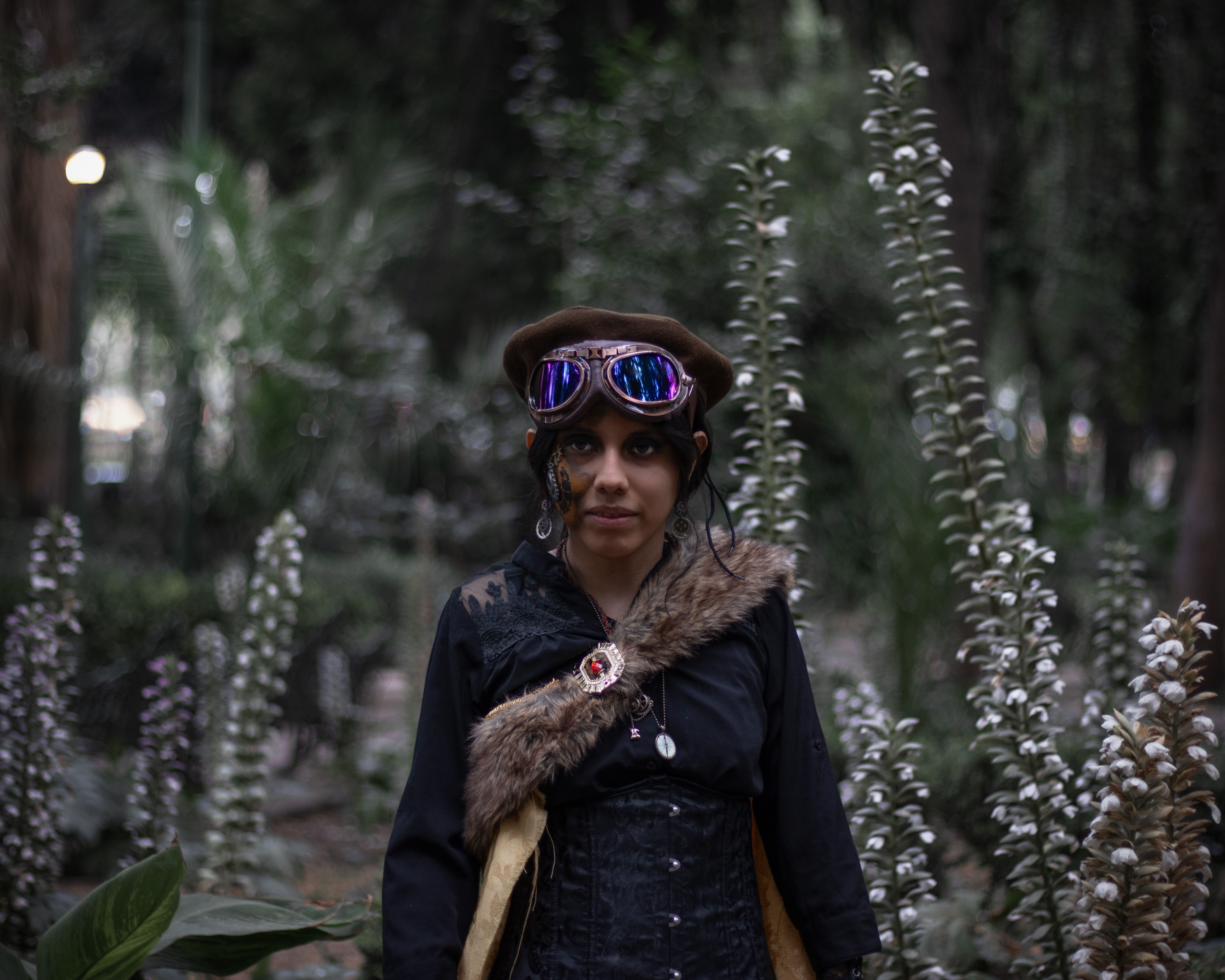 A young woman in steampunk attire poses in a park in Ciudad de México.