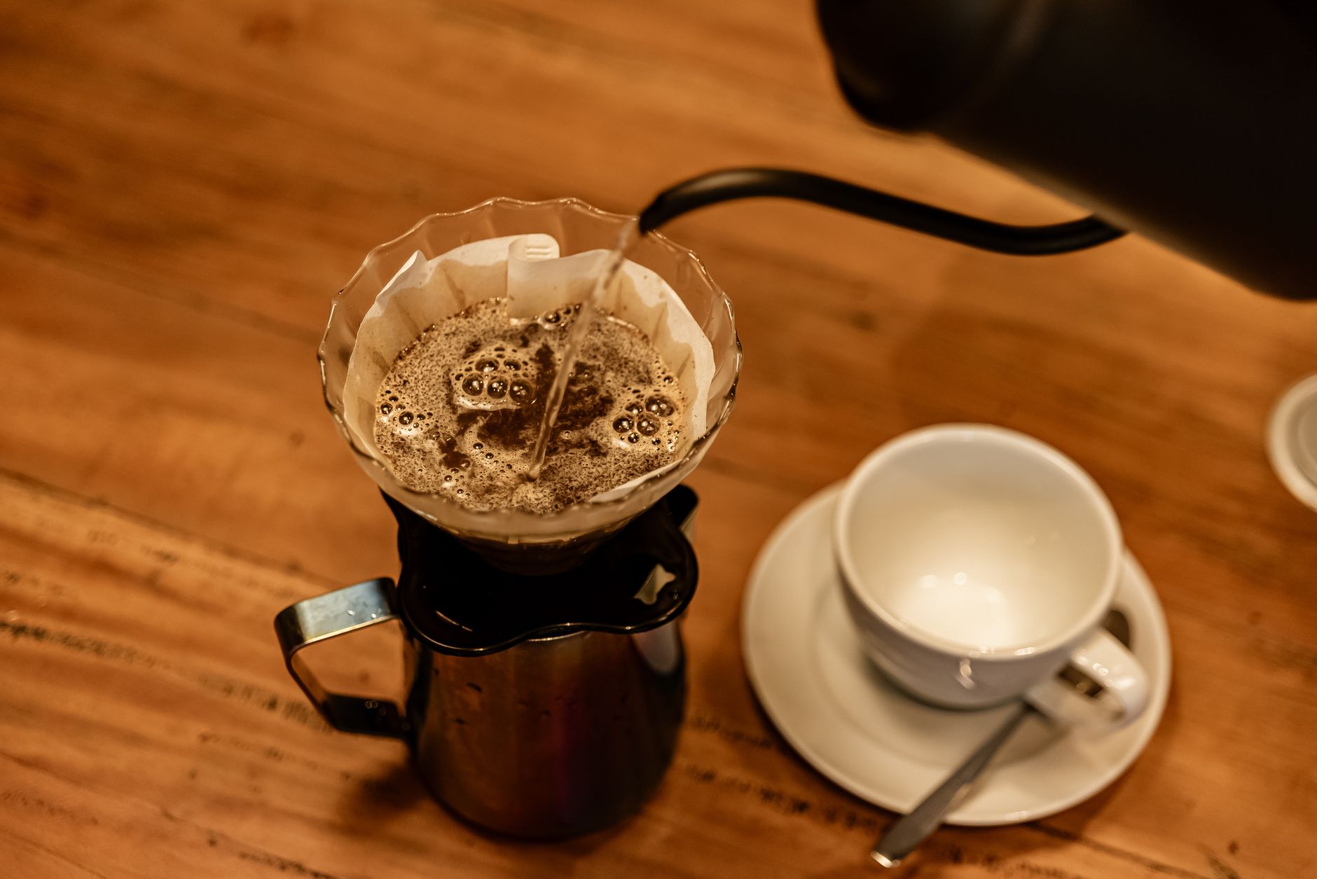 깨끗한 물의 시작: 정수기 설치, 스스로 혹은 전문가와 함께하는 방법 2 Top view of coffee brewing process with hot water pouring over grounds in a filter.