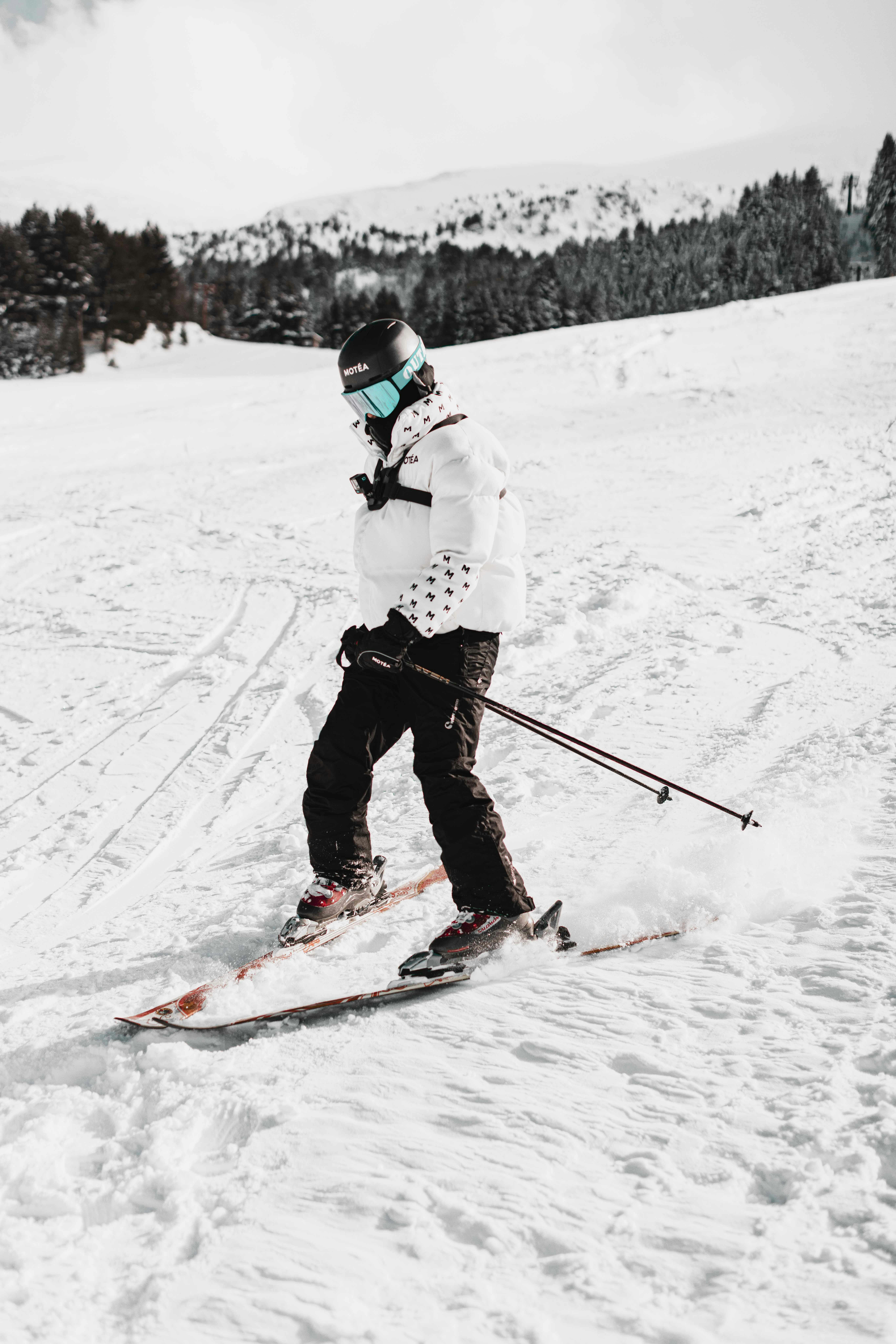 Prescription Goggle Inserts - An adult skier in a white puffer jacket enjoying skiing on snowy slopes in Brezovica, Serbia.